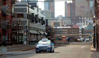 In this Dec. 18, 2018, photo, one of the test vehicles from Argo AI, Ford&#x27;s autonomous vehicle unit, navigates through the strip district near the company offices in Pittsburgh. In the world of autonomous vehicles, Pittsburgh, Phoenix and Silicon Valley are bustling hubs of development and testing. But ask those involved in self-driving vehicles when we might actually see them carrying passengers in every city, and you&#x27;ll get an almost universal answer: Not anytime soon. An optimistic assessment is 10 years. Many others say decades as researchers try to conquer a number of obstacles. (AP Photo/Keith Srakocic)