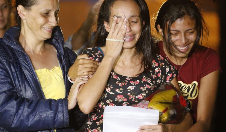 Karen Palacios, center, is helped by family members after she was released from prison at Los Teques on the outskirts of Caracas, Venezuela, Tuesday, July 16, 2019. Palacios who plays the clarinet and was cut from the National Philharmonic for criticizing the government, was detained for 6 weeks. (AP Photo/Ariana Cubillos)