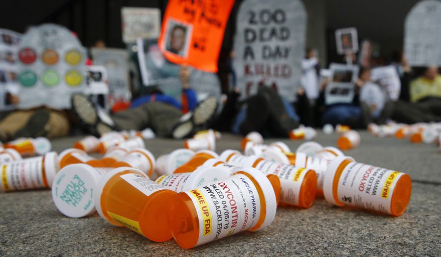 In this April 5, 2019, file photo, containers depicting OxyContin prescription pill bottles lie on the ground in front of the Department of Health and Human Services' headquarters in Washington as protesters demonstrate against the FDA's opioid prescription drug approval practices. (AP Photo/Patrick Semansky, File)