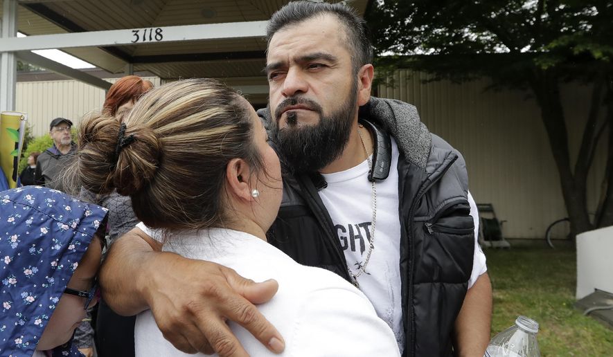 Jose Robles embraces his wife, Susana Robles, after leaving Riverton Park United Methodist Church before walking to present himself to U.S. Immigration and Customs Enforcement officials Wednesday, July 17, 2019, in Tukwila, Wash. Robles, who has spent the past year inside a Seattle church to avoid being deported to Mexico, has been detained. The arrest Wednesday prompted protests from a crowd of supporters who had accompanied Robles to the agency. His deportation has temporarily been put on hold by a federal appeals court, and he has a pending visa application. (AP Photo/Elaine Thompson)