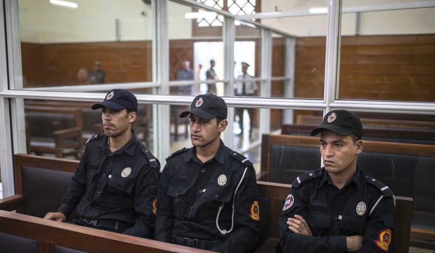 Security forces sit inside a court room before the start of a final trial session for suspects charged in connection with killing of two Scandinavian tourists in Morocco's Atlas Mountains, in Sale, near Rabat, Morocco, Thursday, July 18, 2019. The three main defendants in the brutal slaying of two female Scandinavian hikers have asked for forgiveness from Allah ahead of a verdict. (AP Photo/Mosa'ab Elshamy)