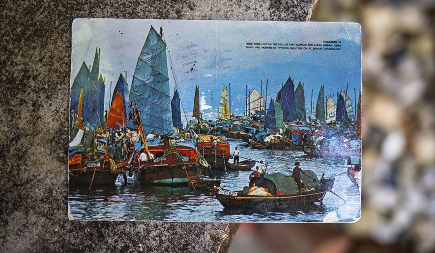 Kim Draper received a postcard, which depicts a scene of fishing boats in Hong Kong, at her home in Springfield on July 8, 2019 that was postmarked and sent from Hong Kong exactly 26 years ago on July 8, 1993 to a previous family that lived at her address. Draper is trying to track down the family that the postcard was sent to, which was addressed to Leena and Muhammad Ali Kizilbash and is signed "See you guys soon. Your Dad." (Justin L. Fowler/The State Journal-Register via AP)
