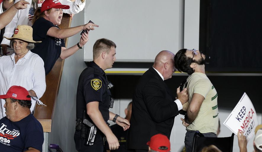 A protester is removed by security as President Donald Trump speaks at a campaign rally in Greenville, N.C., Wednesday, July 17, 2019. (AP Photo/Gerry Broome)