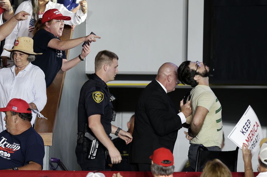 A protester is removed by security as President Donald Trump speaks at a campaign rally in Greenville, N.C., Wednesday, July 17, 2019. (AP Photo/Gerry Broome)