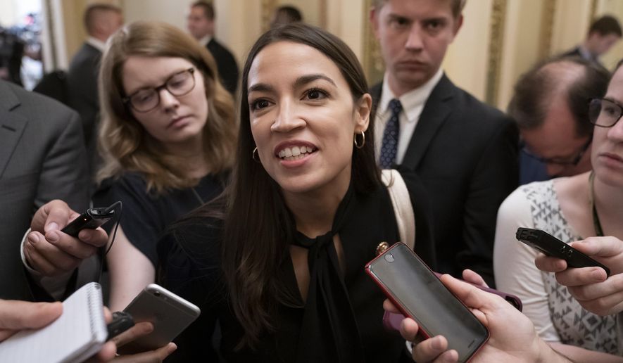 Rep. Alexandria Ocasio-Cortez, D-N.Y., a target of racist rhetoric from President Donald Trump, responds to reporters as she arrives for votes in the House, at the Capitol in Washington, Thursday, July 18, 2019. (AP Photo/J. Scott Applewhite)