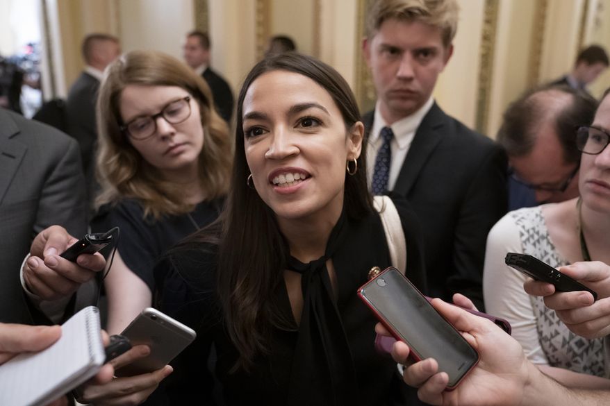 Rep. Alexandria Ocasio-Cortez, D-N.Y., a target of racist rhetoric from President Donald Trump, responds to reporters as she arrives for votes in the House, at the Capitol in Washington, Thursday, July 18, 2019. (AP Photo/J. Scott Applewhite)
