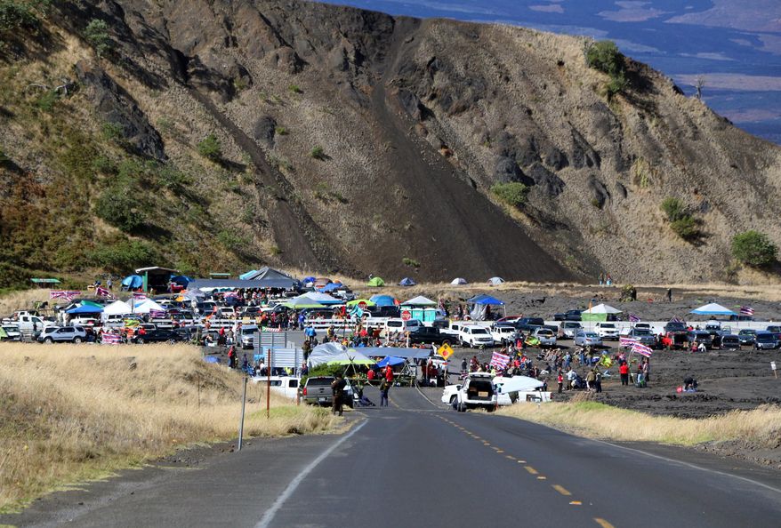 This photo provided by the Hawaii Department of Land and Natural Resources (DLNR) shows people who are against the construction of a Hawaii telescope continuing to block the roadway to the top of Mauna Kea, a mountain considered sacred by some Native Hawaiians, as the protest entered its fourth day Thursday, July 18, 2019. The action Thursday comes a day after 33 people were arrested, many of them elderly. Activists have fought the $1.4 billion Thirty Meter Telescope in courts and on the streets for years, but the latest protest could be their final stand as they run out of legal options. (Hawaii DLNR via AP)