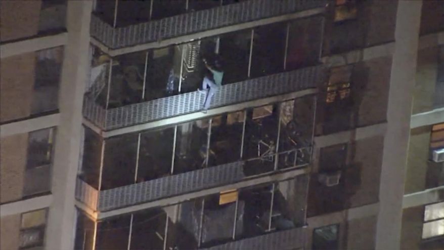This image taken from video provided by WPVI-TV shows a man scaling down the side of a 19-story high-rise building in Philadelphia to escape a fire, Thursday, July 19, 2019. The fire at the Holden Tower started around 9:30 p.m. Thursday. It apparently started in a trash chute, causing flames to shoot out and spread heavy smoke to all floors of the building. (WPVI-TV via AP) MANDATORY CREDIT