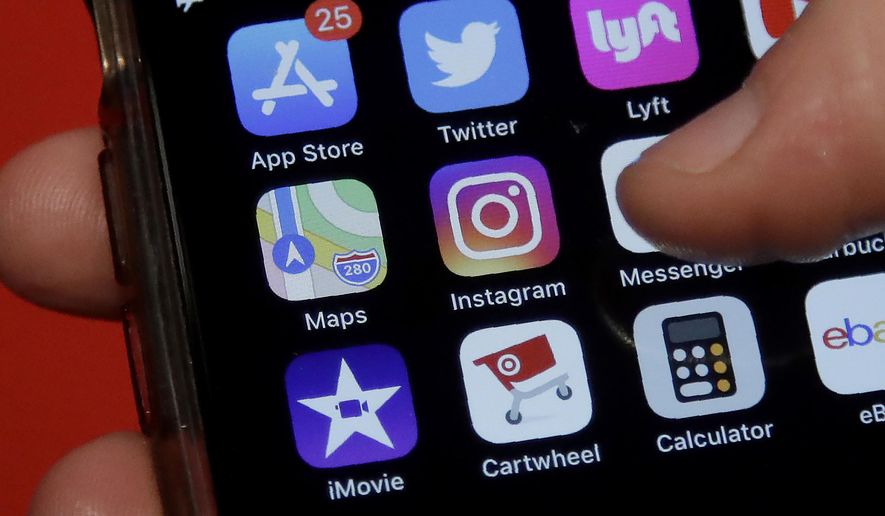This July 10, 2019, photo shows an Associated Press reporter holding a phone showing the Instagram app icon in San Francisco. (AP Photo/Jeff Chiu)