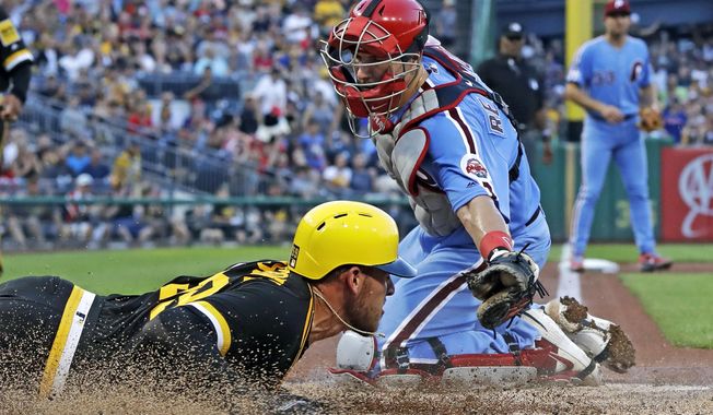 Pittsburgh Pirates starting pitcher Joe Musgrove, left, scores past the tag attempt by Philadelphia Phillies catcher J.T. Realmuto during the third inning of a baseball game in Pittsburgh, Saturday, July 20, 2019. Musgrove scored on a single by Pirates&#x27; Bryan Reynolds off Phillies starting pitcher Zach Eflin. (AP Photo/Gene J. Puskar)