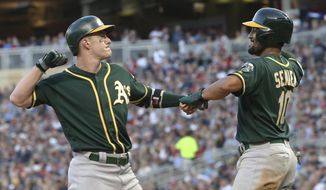 Oakland Athletics&#39; Mark Canha, left, and Marcus Semien celebrate Canha&#39;s two-run home run off Minnesota Twins pitcher Zack Littell in the seventh inning of a baseball game Saturday, July 20, 2019, in Minneapolis. The Athletics won 5-4. (AP Photo/Jim Mone)