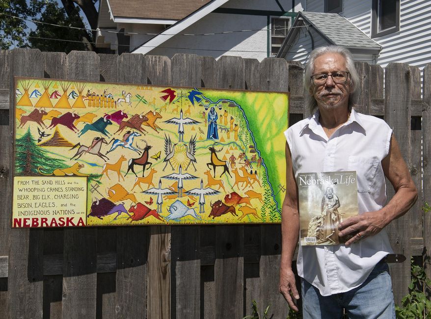 Omaha artist Donel Keeler poses with artwork depicting, "From the sand hills and the whooping cranes, Standing Bear, Big Elk, Charging Bison, Eagles, and the Indigenous Nations we are Nebraska," on Friday, July 12, 2019, at his home in North Omaha.(Kayla Wolf/Lincoln Journal Star via AP)
