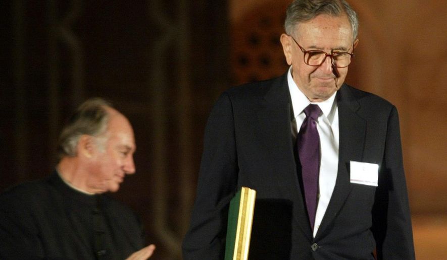 In this Nov. 27, 2004, file photo, Cesar Pelli of Cesar Pelli and Associates US, right, one of the awardees of the Aga Khan Award for Architecture walks with his award as the Aga Khan, spiritual leader of the Shia Imami Ismaili Muslims, claps during the award ceremony at the gardens of Emperor Humayuns Tomb in New Delhi, India. Pelli, known for designing some of the world’s tallest and most iconic buildings, has died. He was 92. Anibal Bellomio, a senior associate architect at Pelli’s Connecticut studio, confirmed Saturday, July 20, 2019, that Pelli died peacefully on Friday at his home in New Haven. (AP Photo/Manish Swarup)