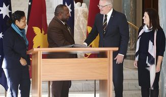 Papua New Guinea&#39;s Prime Minister James Marape, second from left, shakes hands with Australian Prime Minister Scott Morrison, watched by their respective wives Rachael Marape, left, and Jenny Morrison after signing the visitors&#39; book at Australia&#39;s Parliament House in Canberra Monday, July 22, 2019. Marape says his country&#39;s relationship with China in not open to discussion during his current visit to Australia. (AP Photograph/Rod McGuirk)