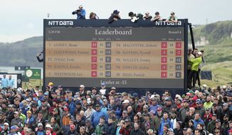 Spectators clamber on to and on top of a scoreboard as they vie to get a glimpse of Ireland&#39;s Shane Lowry and England&#39;s Tommy Fleetwood as they play during the final round of the British Open Golf Championships at Royal Portrush in Northern Ireland, Sunday, July 21, 2019. (AP Photo/Peter Morrison)