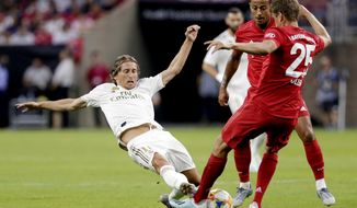 Real Madrid forward Gareth Bale, left, slides as he goes for the ball against FC Bayern&#x27;s Thiago Alcântara, center, and Thomas Muller (25) during the first half of an International Champions Cup soccer match Saturday, July 20, 2019, in Houston. (AP Photo/Michael Wyke)