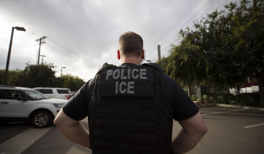 In this July 8, 2019, file photo, a U.S. Immigration and Customs Enforcement (ICE) officer looks on during an operation in Escondido, Calif. Advocacy groups and unions are pressuring Marriott, MGM and others not to house migrants who have been arrested by U.S. Immigration and Customs Enforcement agents. But the U.S. government says it sometimes needs bed space, and if hotels don’t help it might have to split up families. (AP Photo/Gregory Bull, File)