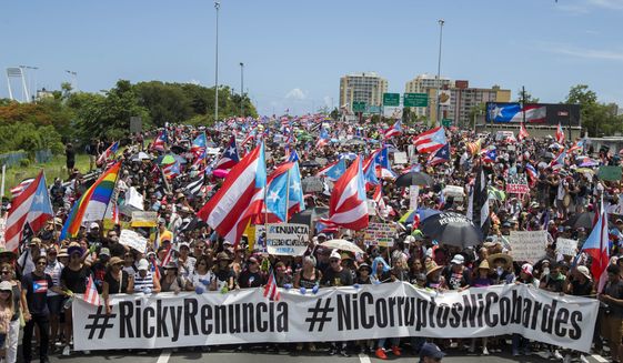 Thousands of Puerto Ricans gather for what many are expecting to be one of the biggest protests ever seen in the U.S. territory, with irate islanders pledging to drive Gov. Ricardo Rossello from office, in San Juan, Puerto Rico, Monday, July 22, 2019. Protesters are demanding Rossello step down for his involvement in a private chat in which he used profanities to describe an ex-New York City councilwoman and a federal control board overseeing the island&#39;s finance.(AP Photo/Dennis M. Rivera Pichardo)