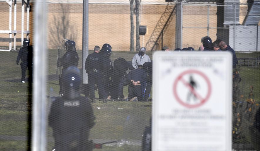 A juvenile detainee, at center, is on his knees while being arrested during a riot at the Frank Baxter Juvenile Justice Centre, at Kariong, Australia, Monday, July 22, 2019. Police say several inmates have been injured during a riot at an Australian juvenile detention center that was continuing after starting the previous night. (Dean Lewins/AAP Image via AP)