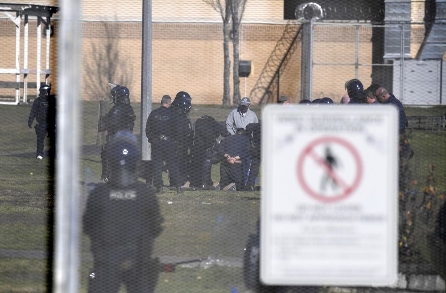 A juvenile detainee, at center, is on his knees while being arrested during a riot at the Frank Baxter Juvenile Justice Centre, at Kariong, Australia, Monday, July 22, 2019. Police say several inmates have been injured during a riot at an Australian juvenile detention center that was continuing after starting the previous night. (Dean Lewins/AAP Image via AP)