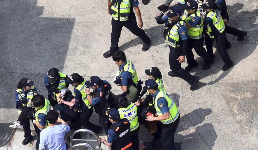 CORRECTS DATE - South Korean police officers detain protesters in front of the Japanese consulate in Busan, South Korea, Monday, July 22, 2019. South Korean police say they've detained six people for allegedly illegally entering a Japanese diplomatic facility in South Korea. (Huh Kyung-min/Newsis via AP)