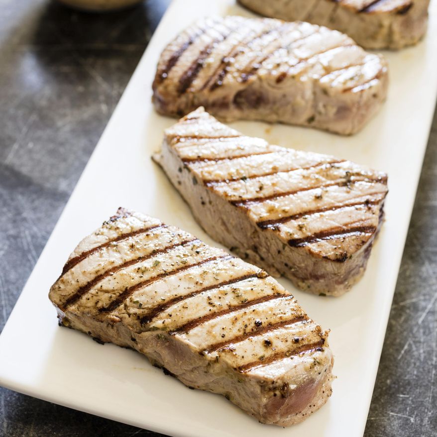 This undated photo provided by America's Test Kitchen in July 2019 shows Grilled Tuna Steaks with Vinaigrette in Brookline, Mass. This recipe appears in the cookbook “Master of the Grill.” (Daniel J. van Ackere/America's Test Kitchen via AP)