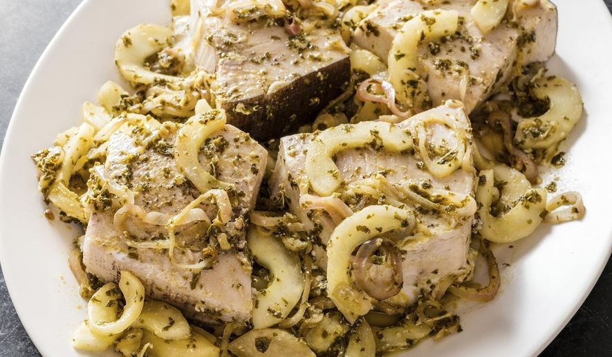 This undated photo provided by America's Test Kitchen in July 2019 shows Swordfish en Cocotte with Shallots, Cucumber and Mint in Brookline, Mass. This recipe appears in the cookbook "Complete Mediterranean." (Daniel J. van Ackere/America's Test Kitchen via AP)