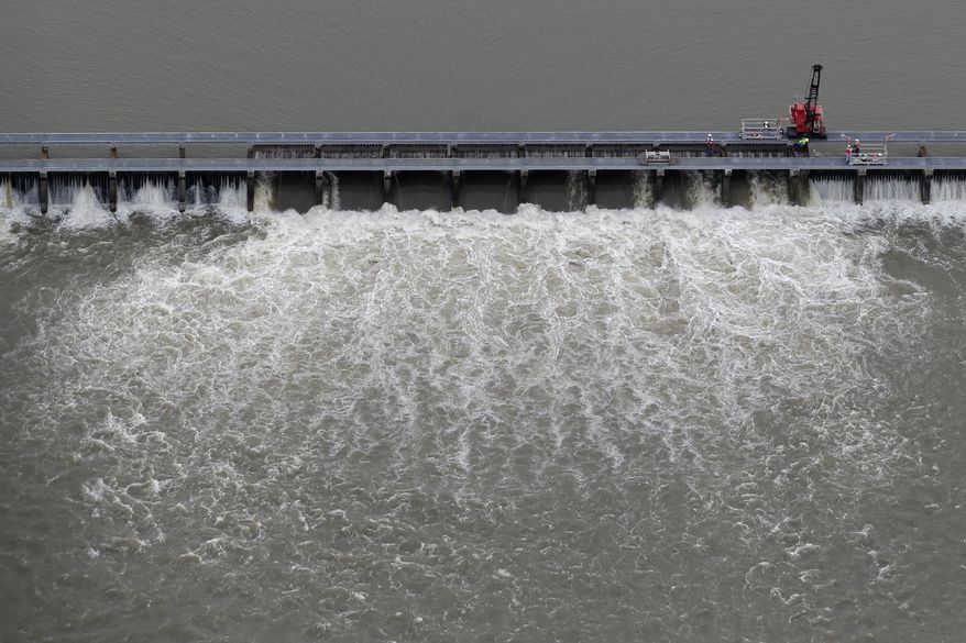FILE - In this May 10, 2019 file photo, workers open bays of the Bonnet Carre Spillway, to divert rising water from the Mississippi River to Lake Pontchartrain, upriver from New Orleans, in Norco, La. After more than 10 weeks, the Mississippi River is low enough to let the Army Corps of Engineers begin closing the huge spillway west of New Orleans, the corps said in a news release Monday, July 22, 2019. (AP Photo/Gerald Herbert, File)