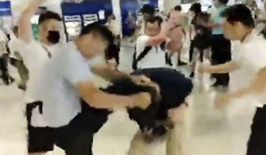 In this image taken from a video footage run by The Stand News via AP Video, white shirted men attacked a man dressed in black shirt at a subway station in Hong Kong on Sunday, July 21, 2019. China doesn't want to intervene in Hong Kong's protests but that doesn't mean it won't, as a thuggish attack on the protesters brought accusations of connivance between police and criminal gangs. (The Stand News via AP Video) HONG KONG OUT