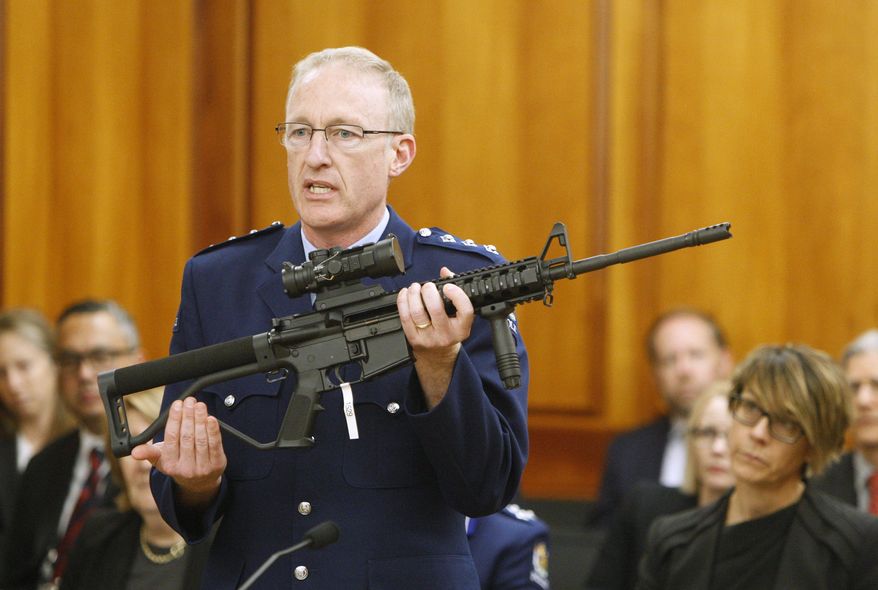 In this April 2, 2019, file photo, police acting superintendent Mike McIlraith shows New Zealand lawmakers an AR-15 style rifle similar to one of the weapons a gunman used to slaughter 51 people at two mosques, in Wellington, New Zealand. New Zealand's government is planning further restrictions on gun ownership in a proposed law that emphasizes owning guns is a privilege and not a right. (AP Photo/Nick Perry, File)