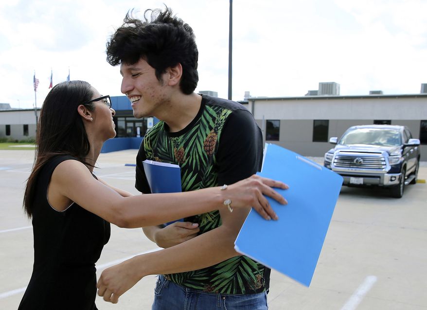U.S. citizen Francisco Galicia, 18, gets a hug from his attorney, Claudia Galan, after his release from the South Texas Detention Facility in Pearsall, Texas, Tuesday, July 23, 2019. Galicia was released from immigration custody Tuesday after wrongfully being detained for more than three weeks. (Kin Man Hui/The San Antonio Express-News via AP)