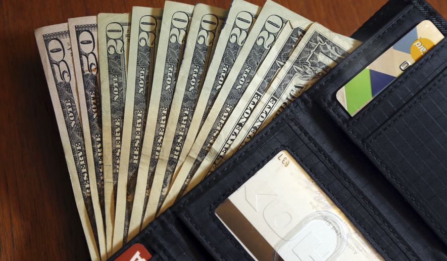 In this June 15, 2018, file photo, cash is fanned out from a wallet in North Andover, Mass. (AP Photo/Elise Amendola, File)