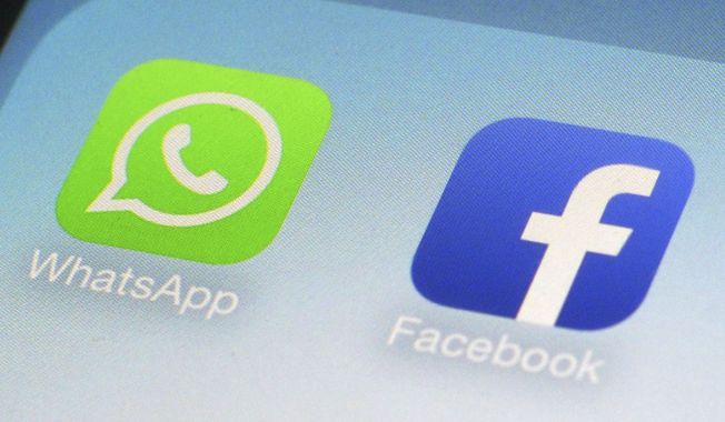 This Feb. 19, 2014, file photo, shows WhatsApp and Facebook app icons on a smartphone in New York. (AP Photo/Patrick Sison, File)