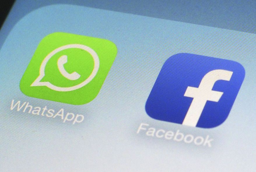 This Feb. 19, 2014, file photo, shows WhatsApp and Facebook app icons on a smartphone in New York. (AP Photo/Patrick Sison, File)