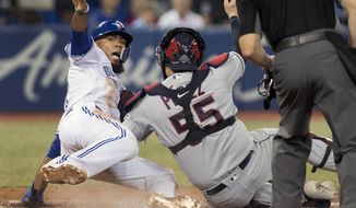 Toronto Blue Jays Teoscar Hernandez is out at home plate as Cleveland Indians catcher Roberto Perez puts the tag on him during the eighth inning of a baseball game, Tuesday, July 23, 2019 in Toronto. (Fred Thornhill/Canadian Press via AP)