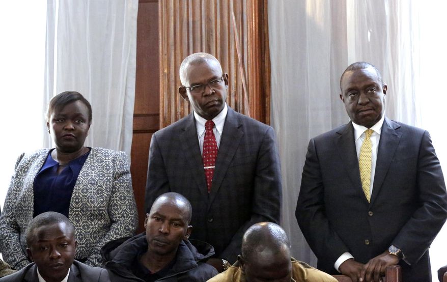From left, Principal Secretary Ministry of East Africa Community Susan Jemtai Koech, Principal Secretary National Treasury Kamau Thugge, and Cabinet Secretary for National Treasury Henry Kiplagat Rotich appear with other suspects accused of corruption, at the Mililani law court in Nairobi, Tuesday, July 23, 2019. Kenya’s finance minister Tuesday denied fraud-related charges over contracts for the construction of two dams in the country’s west. This is the first time a Kenyan finance minister has been charged while in office. Henry Rotich and 14 other officials appeared in court after spending the night in police custody. (AP Photo/Khalil Senosi)