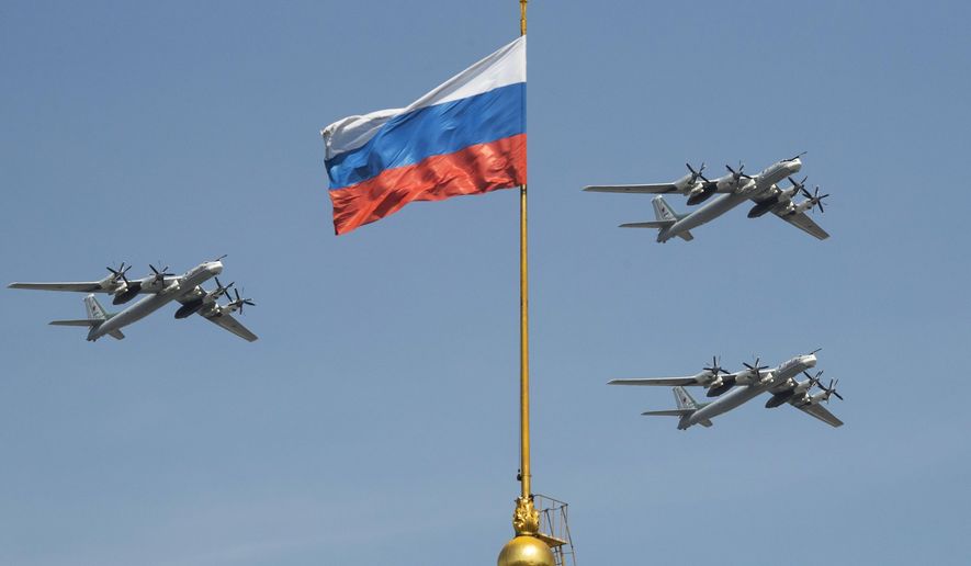 In this file photo taken on Friday, May 4, 2018, Russian Tu-95 strategic bombers fly past the Russian flag on the Kremlin complex during a rehearsal for the Victory Day military parade in Moscow, Russia.  South Korean air force jets fired 360 rounds of warning shots after a Russian military plane briefly violated South Korea&#x27;s airspace twice on Tuesday, Seoul officials said, in the first such incident between the two countries. (AP Photo/Pavel Golovkin, File)