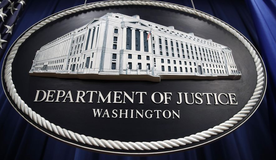 In this Thursday, April 18, 2019, file photo, a sign for the Department of Justice hangs in the press briefing room at the Justice Department, in Washington. (AP Photo/Patrick Semansky, File)  **FILE**