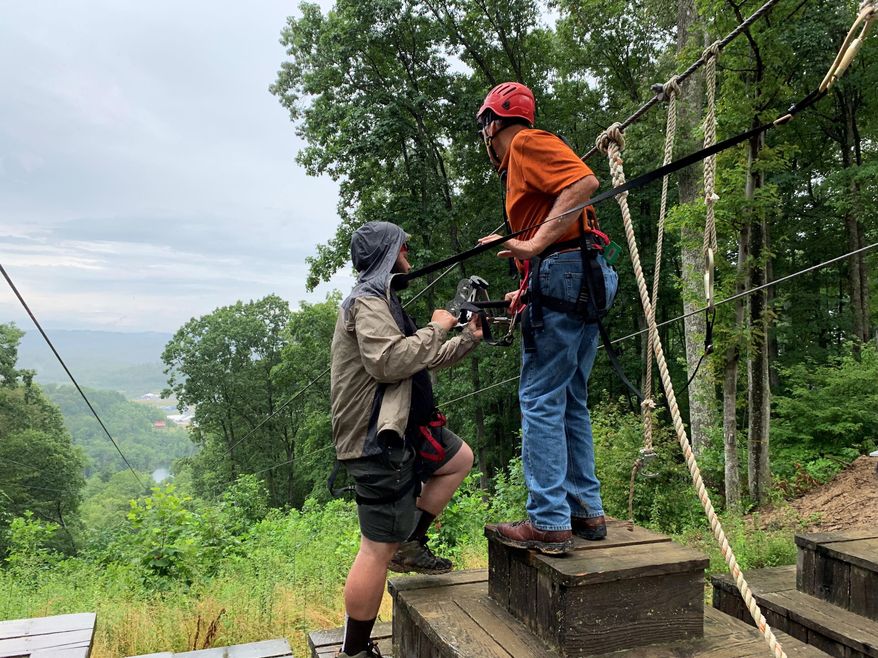 This Monday, July 22, 2019, photo released by the Office of U.S. Sen. Joe Manchin shows Manchin, right, before taking a zipline ride at the World Scout Jamboree in Glen Jean, W.Va. West Virginia's two U.S. senators let their adventuresome sides take over at the World Scout Jamboree. Manchin and Republican Shelley Moore Capito took simultaneous rides on ziplines Monday in southern West Virginia, where 45,000 Scouts and their leaders from around the world are participating in the jamboree held for just the second time in the United States. (Office of Sen. Joe Manchin via AP)