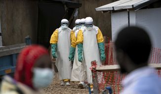 In this Tuesday, July 16, 2019, file photo, health workers wearing protective gear begin their shift at an Ebola treatment center in Beni, Congo. On July 17, the World Health Organization declared the Ebola outbreak an international emergency after it spread to eastern Congo&#39;s biggest city, Goma. (AP Photo/Jerome Delay)