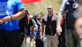 Actor Dwayne &quot;The Rock&quot; Johnson walks on Mauna Kea Access Road during a visit to the protest site against the TMT telescope on Wednesday, July 24, 2019, at the base of Mauna Kea on Hawaii Island. (Jamm Aquino/Honolulu Star-Advertiser via AP)