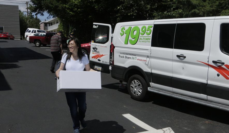 Linda Yang, with the 'Let People Vote' campaign, carries a box of signed petitions for Referendum 88, on Wednesday, July 24, 2019, in Olympia, Wash. Proponents of the referendum are opposed to an affirmative action measure approved by the Legislature earlier this year that permits state agencies to establish diversity goals and timelines, and consider membership in a minority group as a contributing factor for an applicant. (AP Photo/Rachel La Corte)