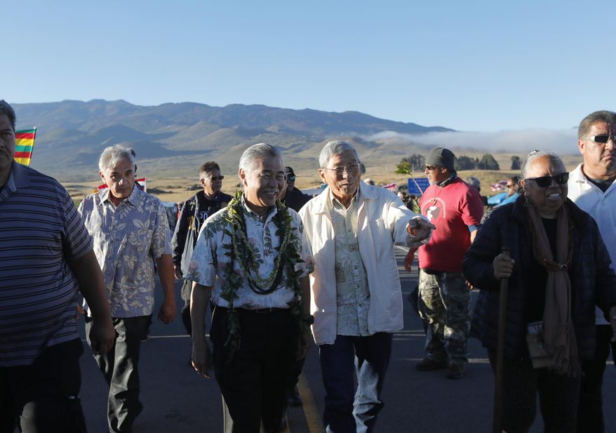 Hawaii governor David Ige, second from left, walks with Big Island mayor Harry Kim as kupuna Noe Noe Wong-Wilson walks at right after a visit to the ninth day of protests against the TMT telescope on Tuesday, July 23, 2019 at the base of Mauna Kea on Hawaii Island. The governor of Hawaii on Tuesday visited protesters blocking the construction of a giant telescope on the state's tallest mountain while acknowledging that their grievances were not just about a new observatory but also about the treatment of Native Hawaiians going back more than a century. (Jamm Aquino/Honolulu Star-Advertiser via AP)
