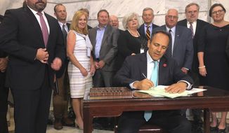 Kentucky Gov. Matt Bevin signs into law a pension-relief bill that won final approval in the state legislature on Wednesday, July 24, 2019, in Frankfort, Ky. The Republican called lawmakers into a special session to take up his pension proposal for regional universities and quasi-governmental entities hit by massive increases in retirement costs.  (AP Photo/Bruce Schreiner)
