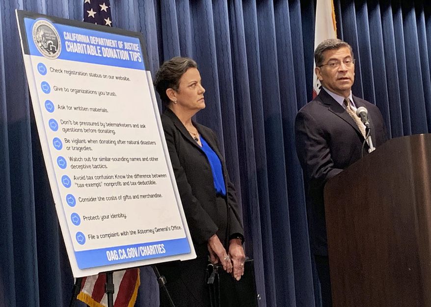 California Attorney General Xavier Becerra, right, and senior Assistant Attorney Genera Tania Ibanez announce a lawsuit the state has filed alleging misdeeds by Move America Forward, a nonprofit that sends packages of food, clothes or other items to military service personnel, at a Los Angeles news conference Wednesday, July 24, 2019. (AP Photo/Natalie Rice)