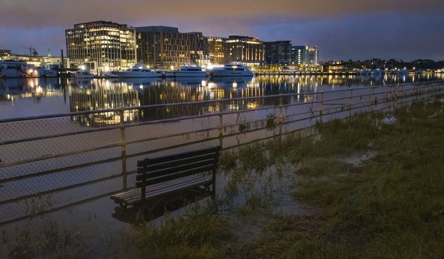 The Washington Channel overflows its banks early in the morning near the southwest Washington waterfront, Tuesday, Sept. 18, 2018. For the second time, the main location of the Capital Fringe Festival is the Southwest Waterfront, featuring public benches and cooling shade. (Associated Press)