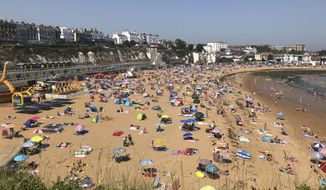 People flock to Broadstairs beach in Kent, England, Thursday July 25, 2019. Paris and London and many parts of Europe are bracing for record temperatures as the second heat wave this summer bakes the continent. The Paris area could be as hot as 42 C (108 F) Thursday as a result of hot, dry air coming from northern Africa that&#39;s trapped between cold stormy systems. (Wesley Johnson/PA via AP)