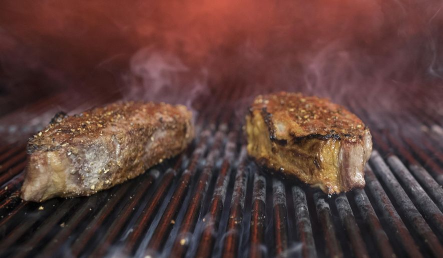 FILE - This Nov. 27, 2018 file photo shows steaks on a grill in New York. (AP Photo/Mary Altaffer, File)