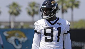 FILE - In this May 21, 2019, file photo, Jacksonville Jaguars defensive end Yannick Ngakoue (91) prepares for drills during an NFL football practice in Jacksonville, Fla. (AP Photo/John Raoux, File)