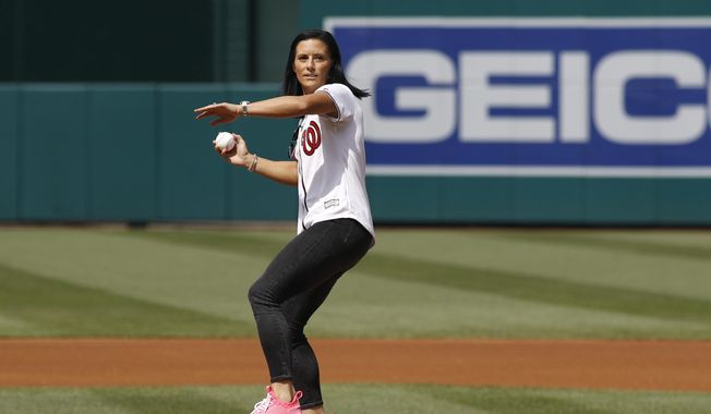 Ali Krieger, a member of the United States women&#x27;s national soccer team, throws out a ceremonial first pitch before a baseball game between the Colorado Rockies and the Washington Nationals, Thursday, July 25, 2019, in Washington. (AP Photo/Patrick Semansky)